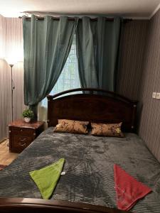 a bedroom with a bed with green and red pillows at ArArAt-POZNYAKI Hostel KYIV in Kyiv