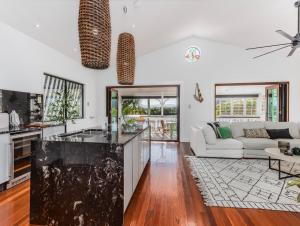 a kitchen and living room with a white couch at Riviera Palms in Tumbulgum +19 photos