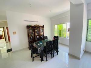 a dining room with a glass table and black chairs at RAJMAYA tower in Sylhet