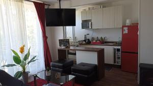 a kitchen with a table and a red refrigerator at Departamento Condominio Parque Pucón in Pucón