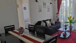 a living room with a black couch and a table at Departamento Condominio Parque Pucón in Pucón