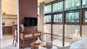 チャウエンノイビーチにあるVilla La Terracotta - Vue Jardin, Villa 18のリビングルーム(テレビ、大きな窓付)