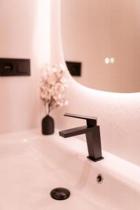 Un baño con un lavabo y un jarrón de flores. en SERAN II Apartamentos, en Ronda