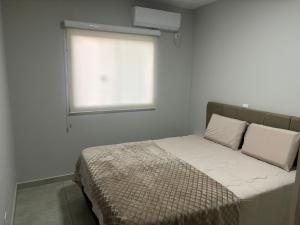 a small bedroom with a bed with a window at Casa em Foz do Iguaçu, Brasil in Foz do Iguaçu