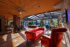 una sala de estar con muebles de cuero rojo y una gran ventana. en Cuci Hotel di Mare Bayramoglu, en Gebze