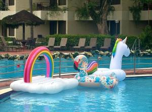 two inflatable flamingos and a unicorn in a swimming pool at Holiday Villa Resort & Beachclub Langkawi in Pantai Cenang
