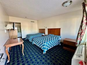 a hotel room with two beds and a desk at Sunset Inn and Suites in Seward +11 photos