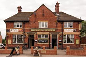 un edificio de ladrillo con una señal que lee los brazos de los martillos en The Miners Arms en Leeds