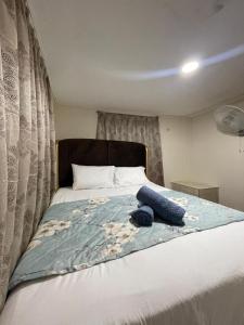 a bedroom with a bed with a blue blanket on it at CuteHomes KB in Kota Belud