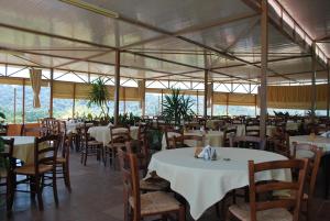 a restaurant with white tables and chairs and tables and chairs at Blue Bay Hotel in Charamida