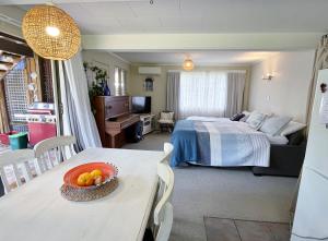 a bedroom with a bed and a table with a bowl of fruit at Feel at Home in Tauranga