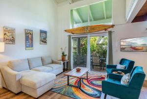 a living room with a couch and a surfboard on the ceiling at Puamana 26B in Princeville