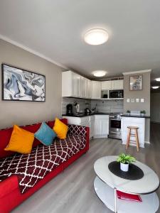 a living room with a red couch and a table at Cozy Galveston Beach Front Condo in Galveston