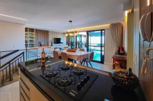 a kitchen with a stove and a dining room at Beverly Hills Cobertura Premium Vista Panorâmica in Mangabeira