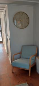 a clock on a wall next to a blue chair at Paddle Wheeler Lilian in Mannum +7 photos