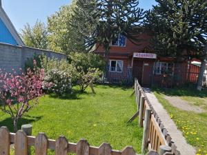 ein Holzzaun vor einem Haus in der Unterkunft Cabaña Patagonia Rustica in Coihaique