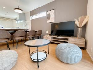 a living room with a tv and a table and chairs at Villa RIKUNOYA SUZUKA in Suzuka