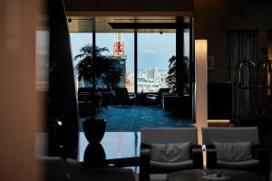 a room with a table and chairs and a view of a city at Park Hotel Tokyo in Tokyo