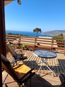 a patio with a table and chairs and the ocean at Cabaña Mi Paraíso in Valparaíso
