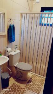 une salle de bain avec une douche avec des toilettes et un lavabo dans l'établissement Piscina e Churrasqueira - 8 minuto a pé da Praia, à Mongaguá