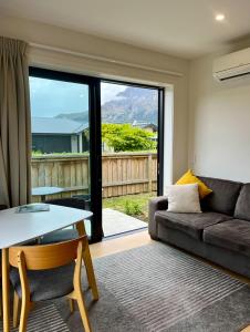 a living room with a couch and a table at Summit View Studio Jacks Point in Queenstown Airport