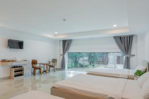 una camera da letto con due letti, un tavolo e delle sedie di Red Coral Hotel a Phan Rang-Tháp Chàm