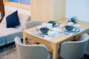 a wooden table with bowls and plates on it at ASOBO OSAKA Nipponbashi Apartment in Osaka