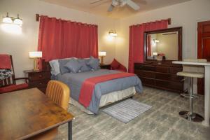a bedroom with a bed and a table and a mirror at Normas Ville in Saint Johnʼs