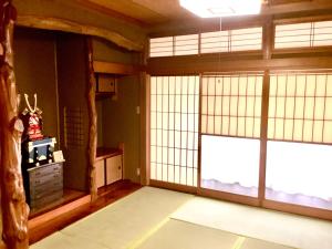 een kamer met grote ramen en een kamer met een tafel bij #熱海古民家 #来宮神社 バーベキュー温泉 in Atami