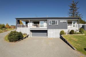 ein großes weißes Haus mit Garage in der Unterkunft Fairway views entire home in Matamata