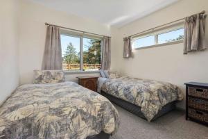 ein Schlafzimmer mit zwei Betten und einem Fenster in der Unterkunft Fairway views entire home in Matamata