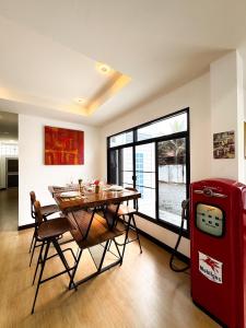 a dining room with a table and a red refrigerator at villa kitty in Ban Thung Satong +15 photos