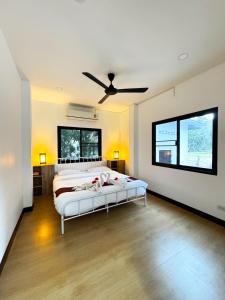 a bedroom with a bed and a ceiling fan at villa kitty in Ban Thung Satong