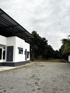 a white building with a roof on a gravel lot at villa kitty in Ban Thung Satong