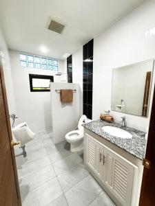 a bathroom with a toilet and a sink and a mirror at villa kitty in Ban Thung Satong