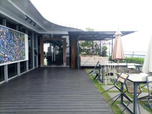 a patio with a table and chairs and an umbrella at Best Homey and Modern Studio at Uttara The Icon Apartment By Travelio in Kejayan