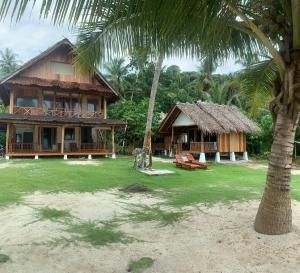 a resort with a palm tree and a building at Lances surf camp in Katiet