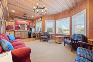 Una sala de estar con un sofá rojo y una cocina. en Laughin Place I home by Peace Vacations, en Pawleys Island