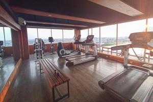 ein Fitnessstudio mit Laufbändern und Trainingsgeräten in einem Gebäude in der Unterkunft Elegant and Cozy Studio Student Park Apartment By Travelio in Seturan