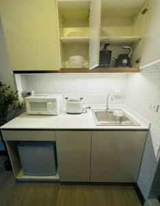a kitchen counter with a sink and a microwave at Pai Cheese cottage in Pai