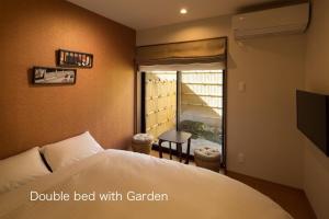 a bedroom with a bed and a window with a balcony at Yukari Kyoto in Kyoto