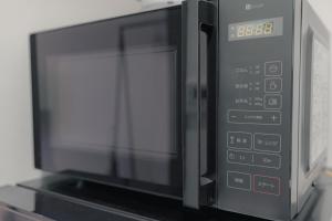 a microwave oven sitting on top of a shelf at Well-rent 名古屋丸の内 in Nagoya