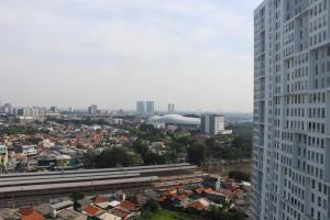 a view of a city with a tall building at Minimalist and Cozy 1BR Patraland Urbano Apartment By Travelio in Bekasi