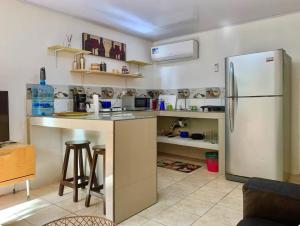 a kitchen with a white refrigerator and a counter at Cabinas Pana Alegría 3 in Puerto Viejo