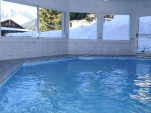 圣母贝莱克Appartement cosy 3 chambres à Notre-Dame-de-Bellecombe - FR-1-807-68的雪屋中的游泳池