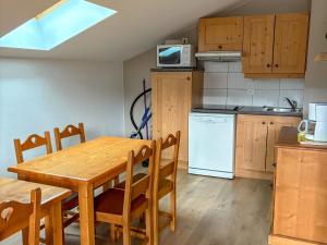 圣母贝莱克Appartement cosy à Notre-Dame-de-Bellecombe, superbe vue - FR-1-807-69的带木桌的厨房和餐厅