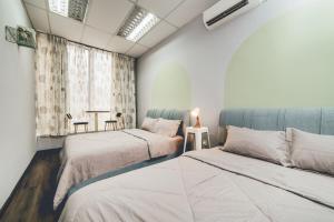 a bedroom with two beds and a table and a window at Tun Aminah Shoplot 10-15pax KTV Mahjong Funhouse by Our Stay in Skudai