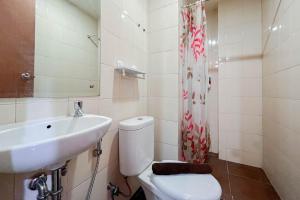 PampangにあるWarm and Cozy 2BR Vida View Makassar Apartment By Travelioのトイレと洗面台付きのバスルーム +7枚の写真