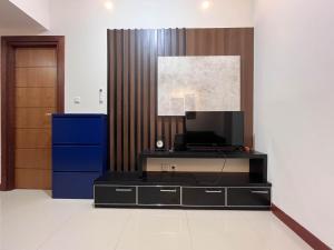 PampangにあるWarm and Cozy 2BR Vida View Makassar Apartment By Travelioの黒い机と青いキャビネットのあるオフィス