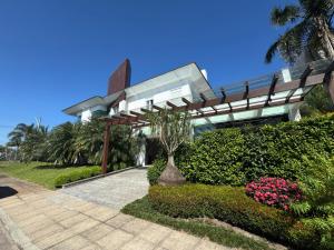 a building with a bench and flowers in front of it at Casa Luxuosa no Condomínio Condado de Capão in Capão da Canoa
